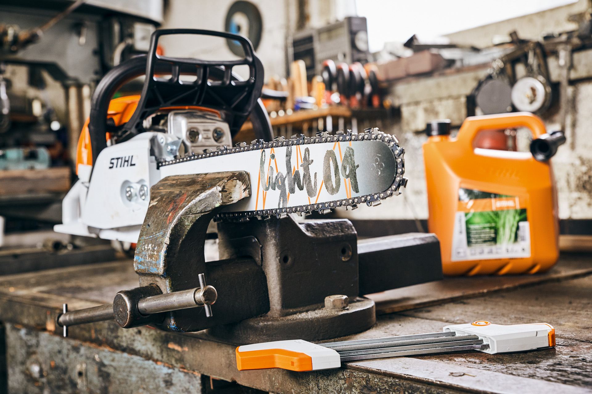 Benzinová řetězová pila STIHL MS 261 C-M s vodicí lištou Light 04 vedle palivové směsi STIHL MotoMix před ostřením
