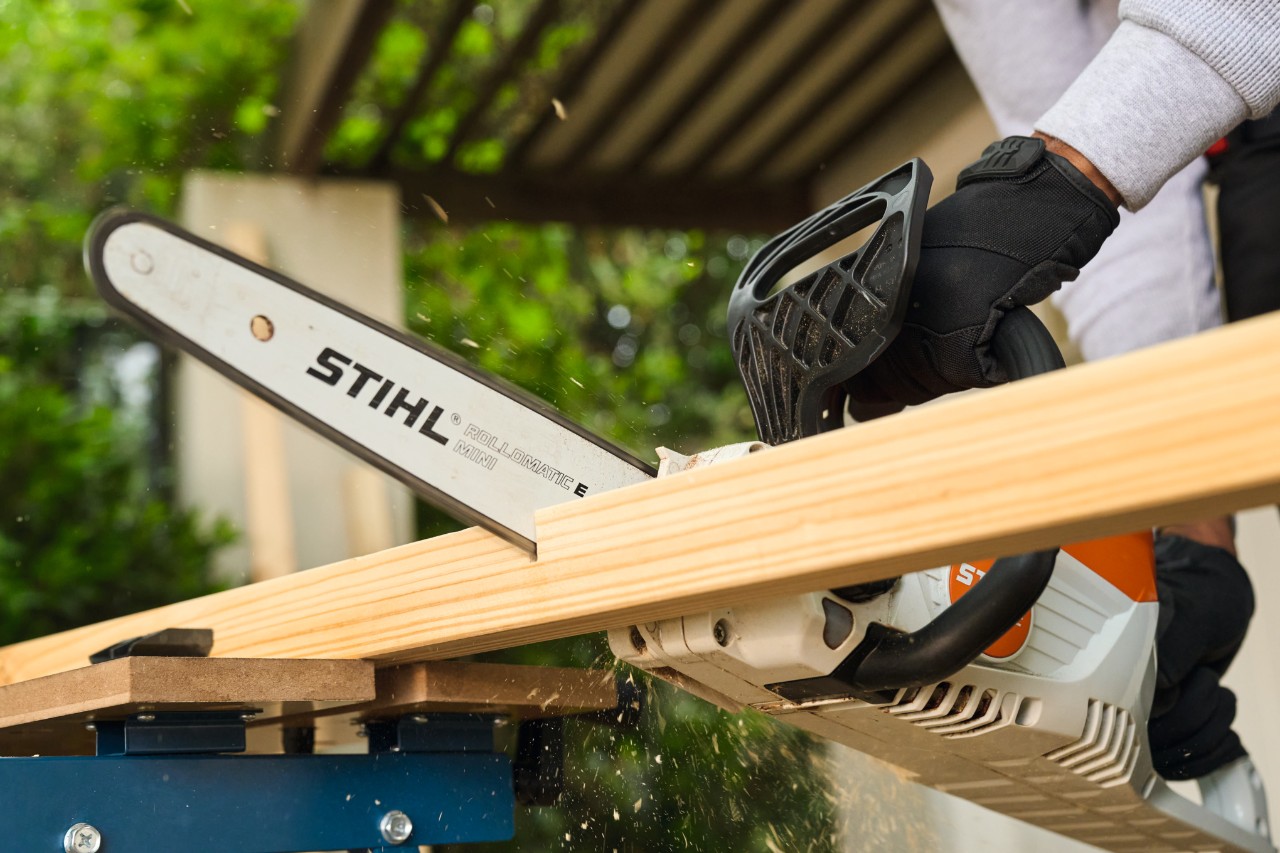 Muž řeže na míru boční vzpěru fotbalové branky řetězovou pilou STIHL MSA 70