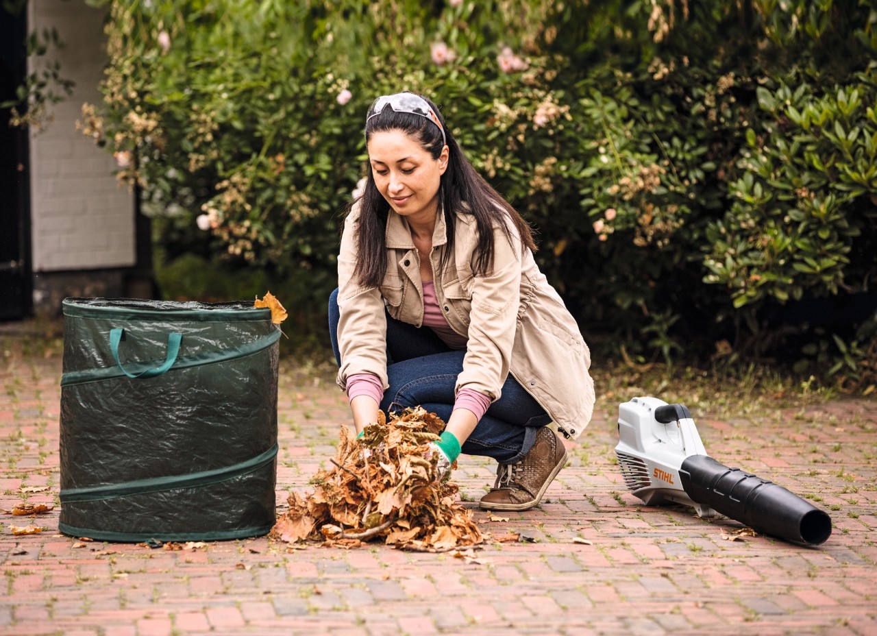 Žena odstraňuje listí pomocí pytle na listí a foukače STIHL BGA 56