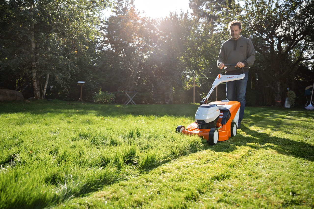 Muž seče trávník na svém pozemku akumulátorovou sekačkou STIHL RMA 448 VC