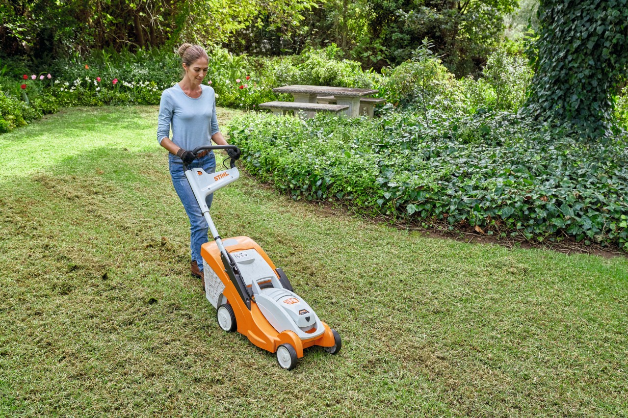 Muž seče jarní trávník akumulátorovou sekačkou STIHL RMA 339 VC