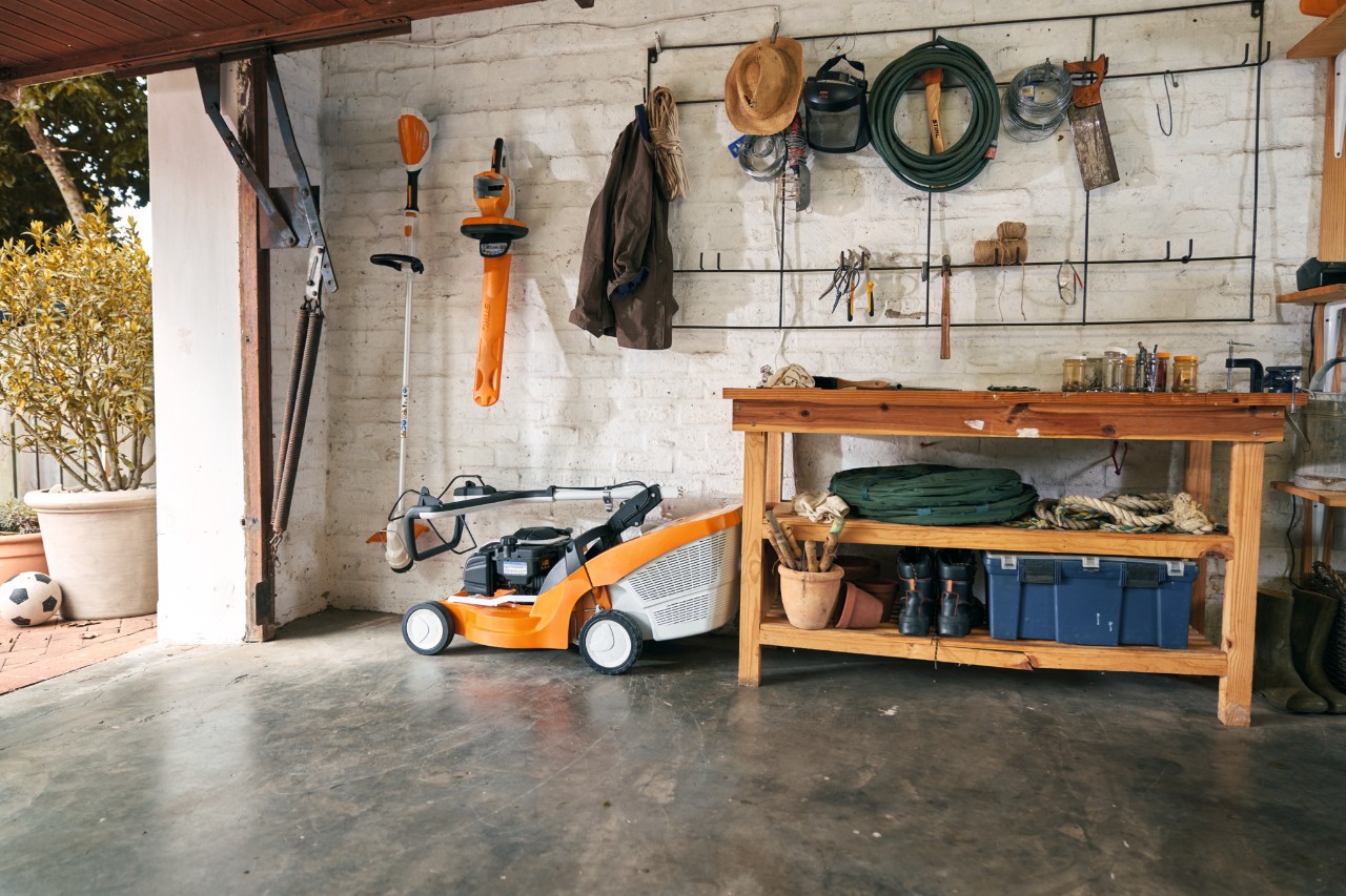 Benzínová sekačka STIHL RM 448 TC vedle jiných zařízení STIHL v garáži