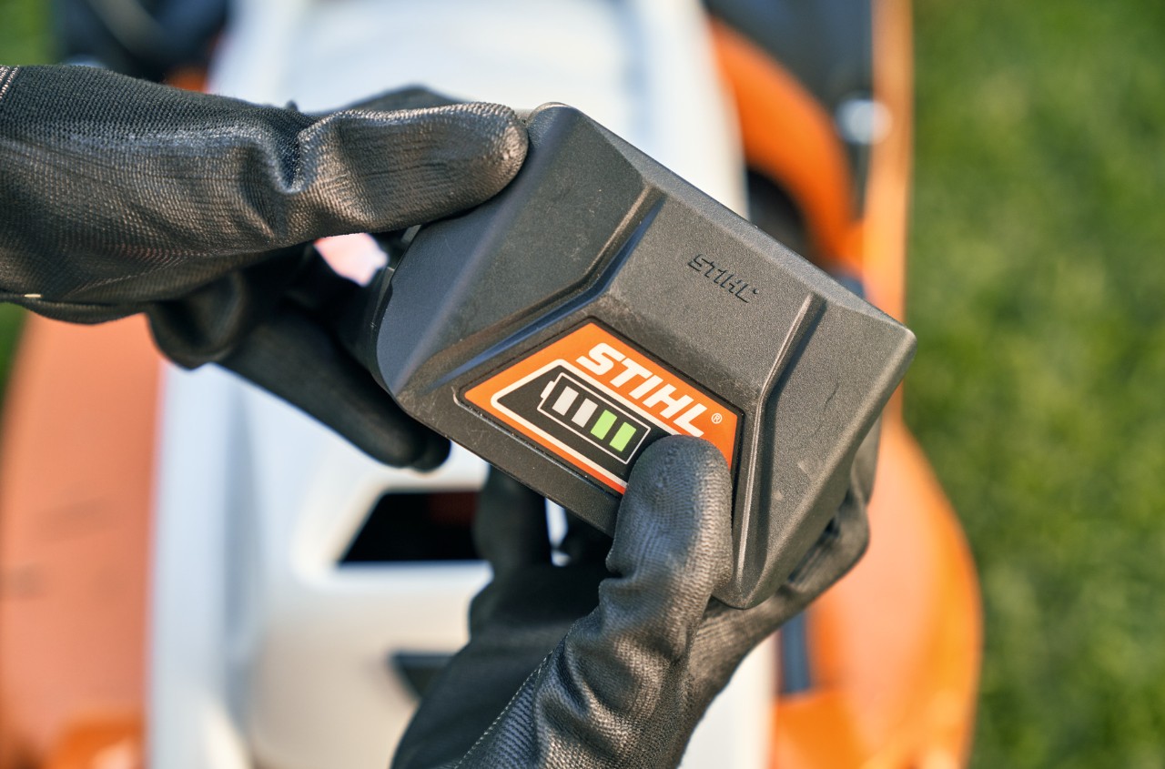 Lithium-iontový akumulátor STIHL, v pozadí akumulátorová sekačka STIHL RMA 339 C