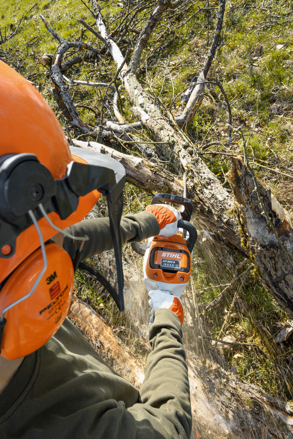Akumulátorová řetězová pila STIHL MSA 220 C-B při práci na kmeni stromu s větvemi