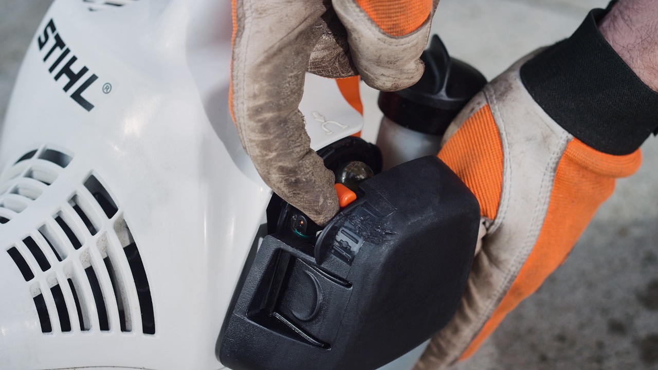 U benzinového vyžínače STIHL FS 38 se stiskne páčka startovací klapky