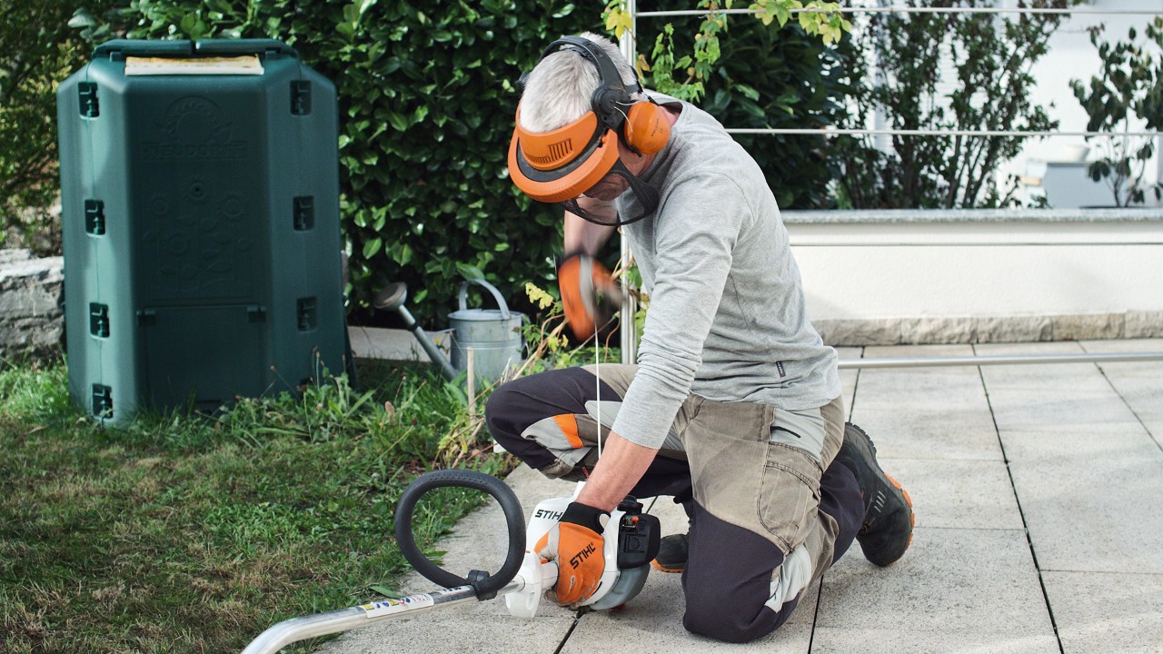 Osoba v ochranném oděvu tahá za startovací lanko benzinového vyžínače STIHL FS 38