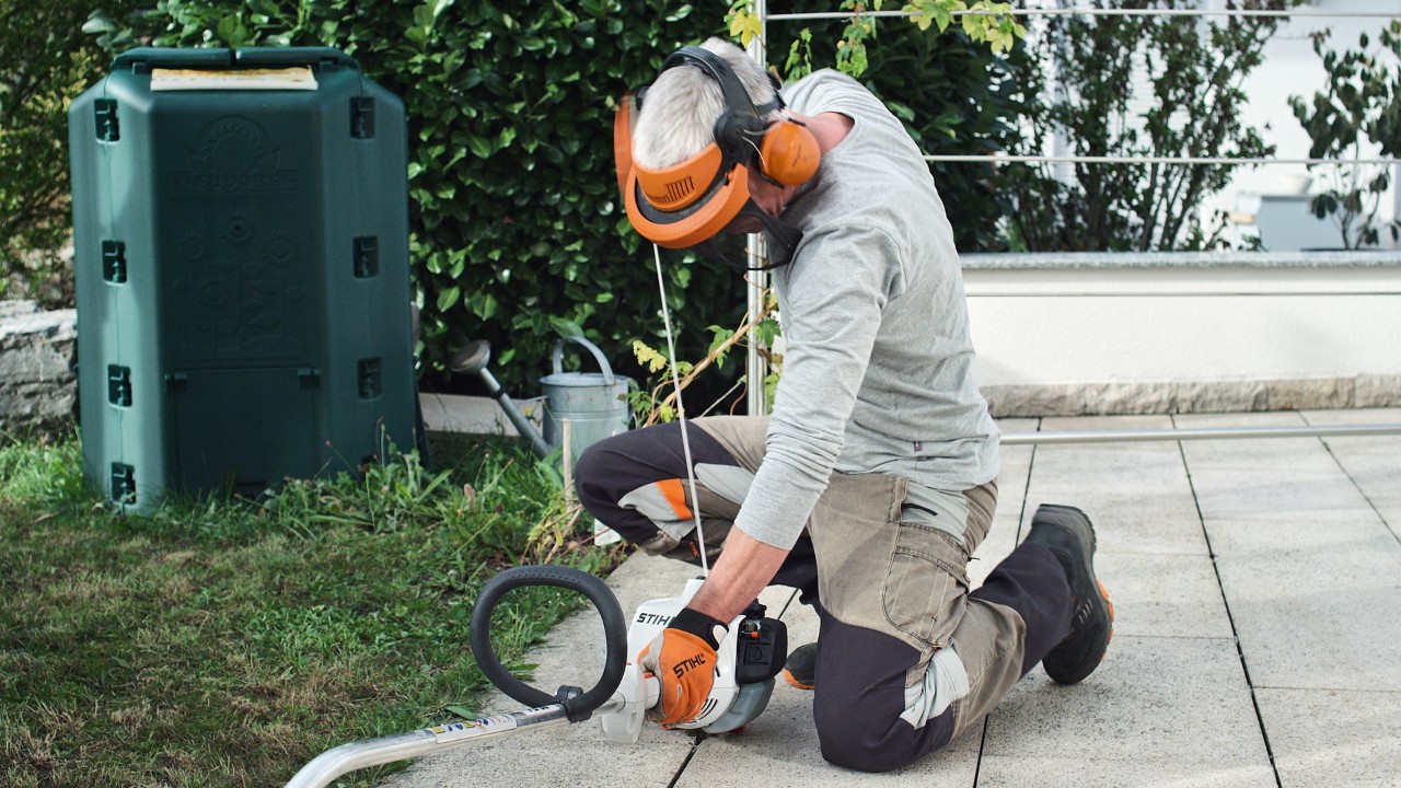 Osoba v ochranném oděvu znovu tahá za startovací lanko benzinového vyžínače STIHL FS 38