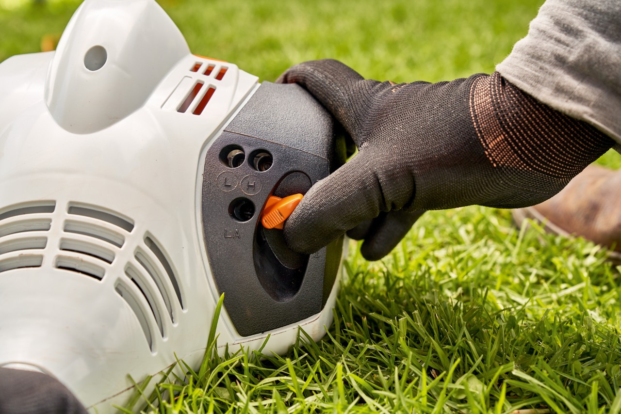 Muž nastavuje páku benzinového vyžínače STIHL FS 56 při startování