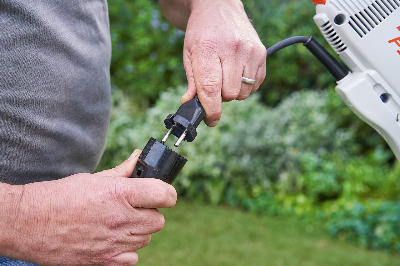 Muž v ochranných rukavicích aktivuje spínač elektrického vyžínače STIHL FSE 60, aby ho nastartoval