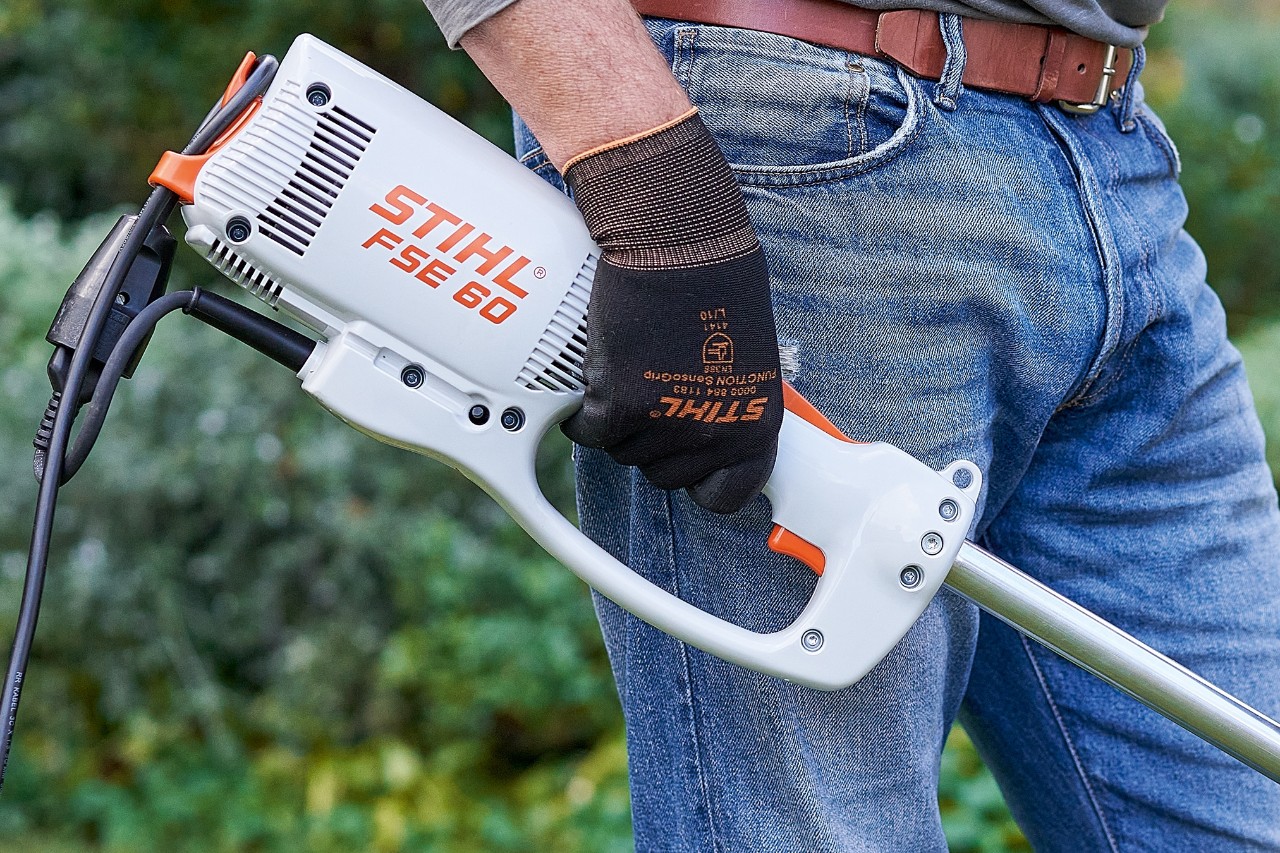 Muž manipuluje se spínačem, aby elektrický vyžínač STIHL FSE 60 vypnul.
