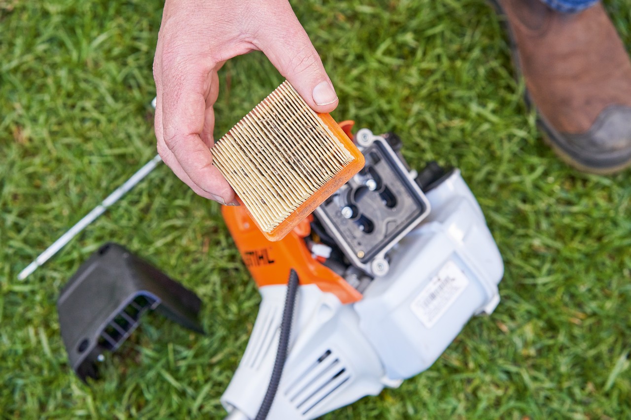 Osoba vysouvá vzduchový filtr vyžínače STIHL, aby ho vyčistila 