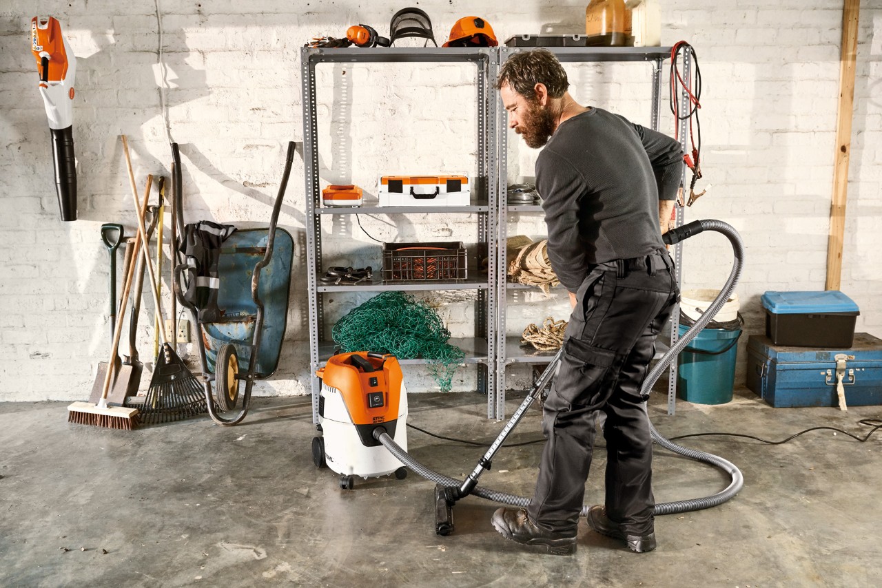Muž vysává podlahu garáže vysavačem pro mokré a suché čištění STIHL SE 62 E
