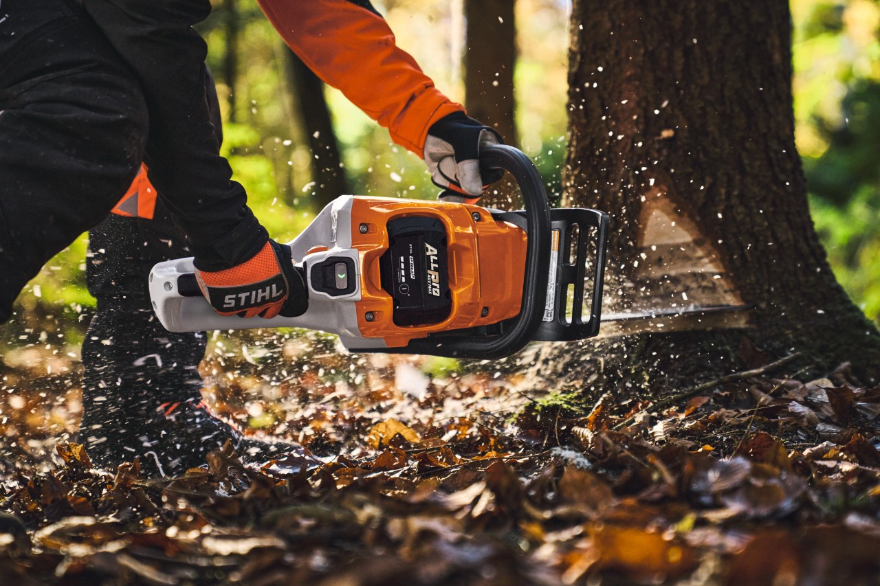 Profesionální uživatel kácí stromy v lese s akumulátorovou motorovou pilou STIHL MSA 260.