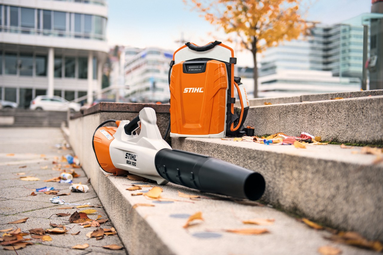 Akumulátorový foukač STIHL BGA 100 a profesionální zádový akumulátor STIHL AR 3000 L leží na kamenném schodišti s listím