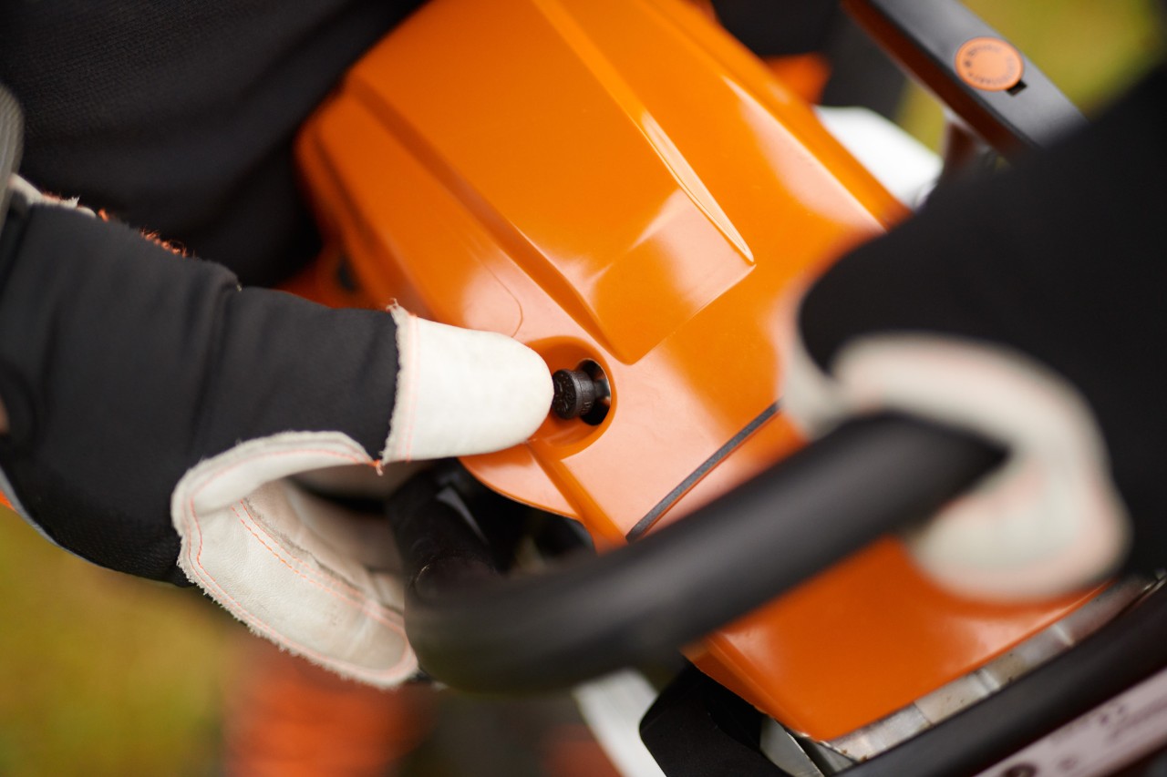 Detailní záběr: Startování benzínové řetězové pily STIHL MS 261 C-M s dekompresním ventilem