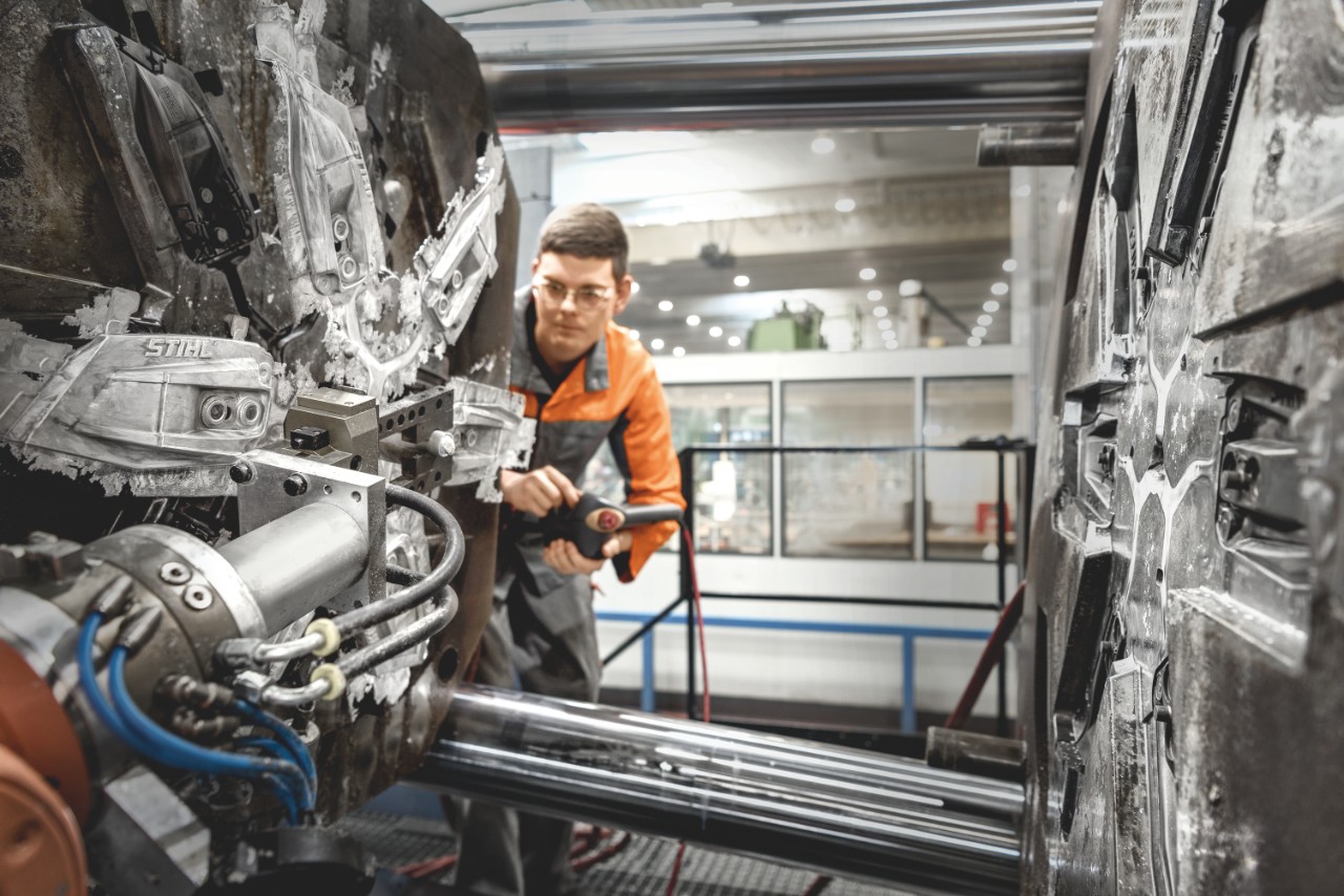 Person operates machine for die-casting process at STIHL plant in Prüm