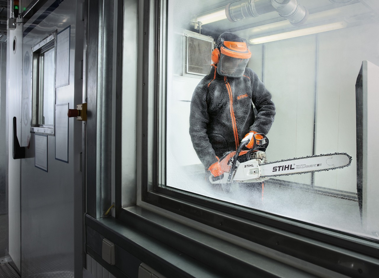 Person in protective clothing tests STIHL chain saw in a climate chamber